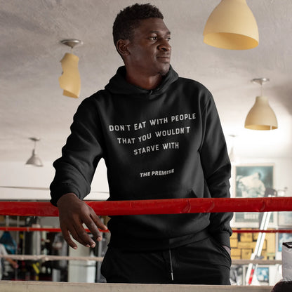 Athlete wearing "Don't Eat with People That You Wouldn't Starve With" hoodie in a boxing gym, symbolizing loyalty and ambition.