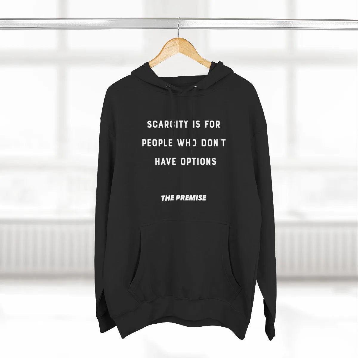 Black hoodie with "Scarcity is for people who don’t have options" quote, hanging on a hanger, representing a mindset of abundance and ambition.