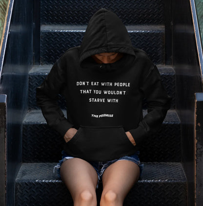 Mysterious and powerful shot of a woman in a black hoodie sitting on urban steps, embodying resilience and ambition.