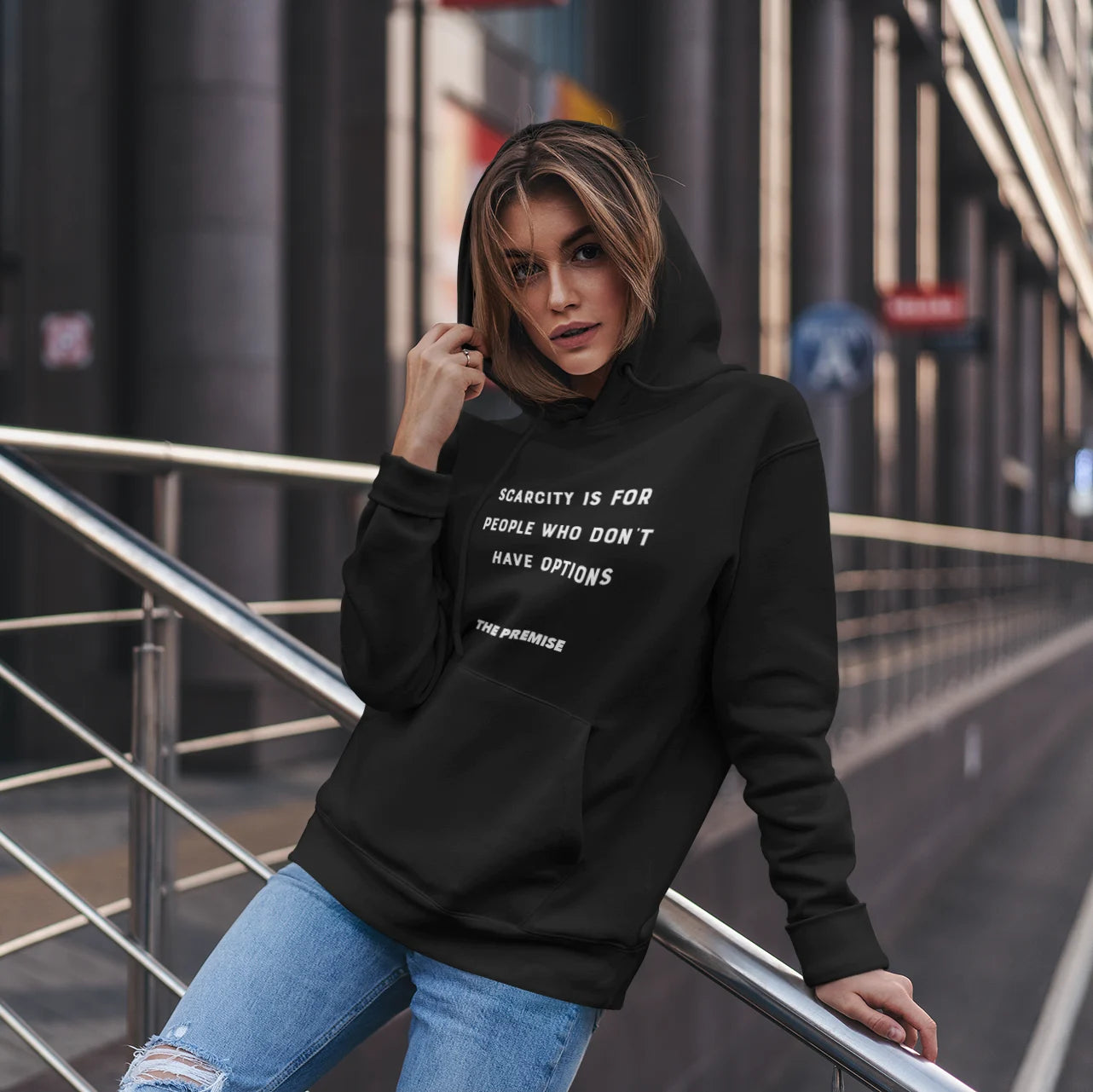 Trendy woman in a black hoodie posing confidently in the city, embodying strength and independence.